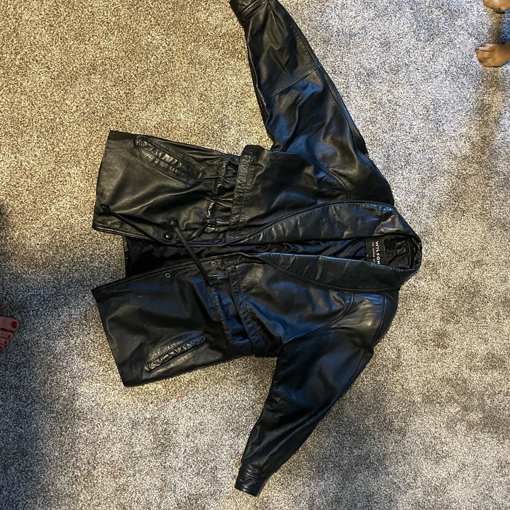 100% leather jacket. Inside and outside pockets. Stomach pull strings. Runs big